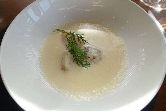 수프로 나온 건관자 포타쥬. 통 관자 3쪽을 올리고 셀러리 잎으로 장식했다.