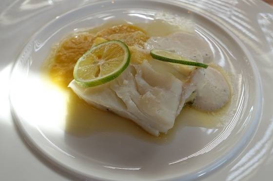 화이트 와인으로 포칭한 생대구. 오렌지를 가미한 해삼 내장 소스(노란색)와 대구 이리(정소) 크림(흰색)이 맛을 더 깊게 해준다.