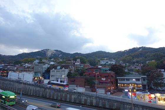 해질녘 ‘프렙’의 창 밖으로 보이는 인왕산 줄기. 왼쪽으로 한양도성과 기차바위가 보이고 자하문터널 북쪽 출입구가 발아래 있다.