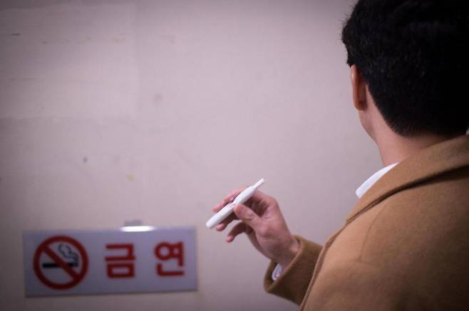 궐련형 전자담배 아이코스를 피우고 있는 한 남성의 뒷모습. 이재호 기자.