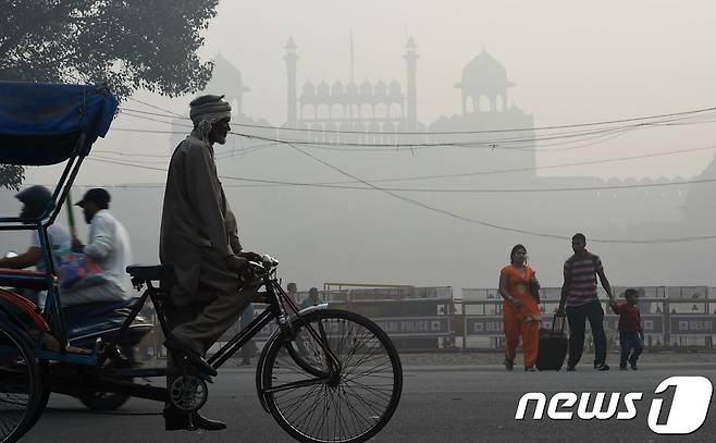 10일 스모그가 짙게 드리운 인도 뉴델리 레드포트 인근에 시민들이 지나가고 있다.  © AFP=뉴스1
