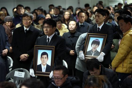 18일 오전 전남 목포신항에서 세월호 미수습자 5명의 추모식이 열려 권재근 씨·혁규 군 유가족이 영정을 운구하고 있다. [연합뉴스]