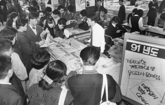 1991학년도 전기대 입학원서 접수를 앞둔 서점의 모습. 전국 대학의 배치기준표 등 각종 입시정보자료집이 불티나게 팔렸다. 학력고사 결과에 따라 전국 대학과 학과를 줄세운 배치기준표는 수험생들에게 절대적인 입시 자료였다. [중앙포토]