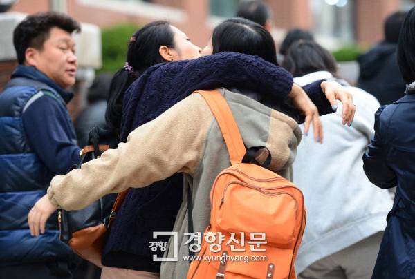 2013학년도 대입 수능이 치러진 2012년 11월 8일 서울 진명여고 앞에서 수험생 학부모가 시험을 치르는 자녀를 안아주고 있다. 김영민 기자
