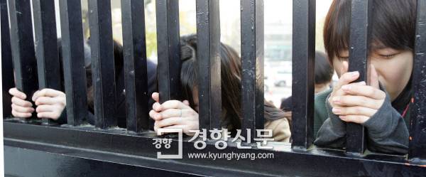 수능시험이 치러진 2004년 11월 17일 학부모들이 서울 풍문여고 교문 밖에서 간절함으로 눈물까지 머금은 채 손모아 기도를 올리고 있다. 경향신문 자료사진