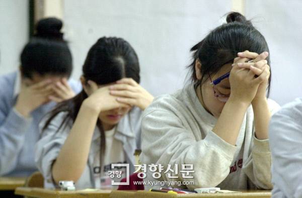 대학수학능력시험이 치러진 2001년 11월 7일 서울 경기여고 고사장에서 한 수험생이 시험에 앞서 모아쥔 양손에 이마를 쥔 채 마음을 가다듬고 있다. 우철훈 기자