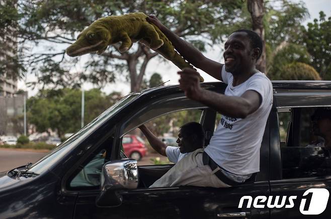 악어 모형을 들어 보이는 짐바브웨 남성. 악어는 음난가그와의 잔인성과 은밀함 때문에 붙은 별명이다. © AFP=뉴스1