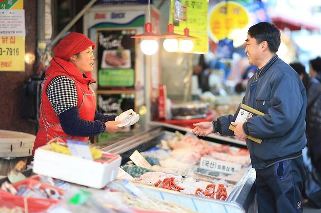최근 경기도 성남시 중원구 은행동 남한산성 전통시장에서 상인과 시민이 지역화폐인 성남사랑상품권을 주고받으며 거래하고 있다. 성남시 제공
