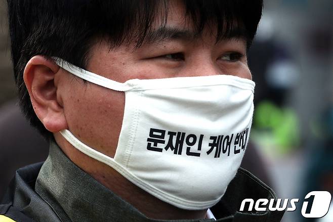 10일 오후 서울 중구 덕수궁 대한문 앞에서 열린 '문재인 케어 반대 및 한의사 의료기기 사용 반대 전국 의사 총궐기대회'에서 한 참가자가 문재인 케어 반대 문구가 들어간 마스크를 쓰고 있다. 2017.12.10/뉴스1 © News1 신웅수 기자