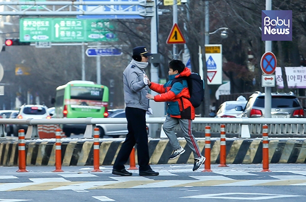 한파경보가 발효된 12일 오전. 한 아이가 횡단보도에서 등굣길을 돕던 파출소 경찰 아저씨와 하이파이브를 하며 지나고 있다. 최대성 기자 ⓒ베이비뉴스