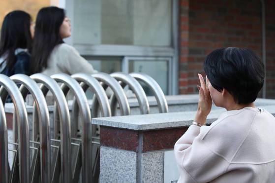 수능일인 지난달 23일 오전 경북 포항시 북구 포항여자전자고등학교에서 한 수험생의 엄마가 고사장으로 들어가는 딸을 바라보며 눈물짓고 있다. [연합뉴스]
