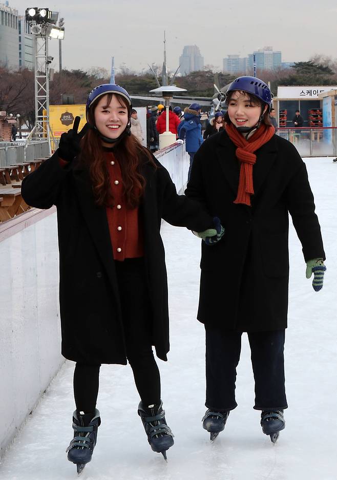 20일 개장한 서울 여의도공원 스케이트장 ‘여의아이스파크’에서 한 여성이 기자의 카메라를 향해 V자를 그려보이고있다.조문규 기자