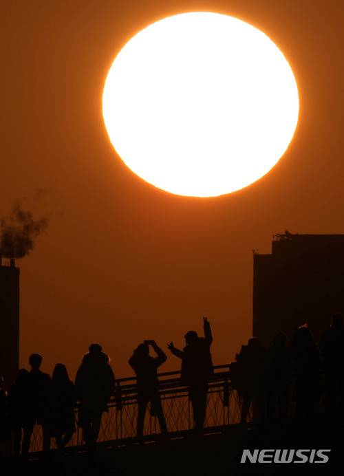 【서울=뉴시스】추상철 기자 = 2018 무술년 새해가 밝은 1일 오전 서울 영등포구 선유도공원 선유교에서 해맞이객이 일출을 배경으로 기념촬영을 하고 있다. 2018.01.01. scchoo@newsis.com