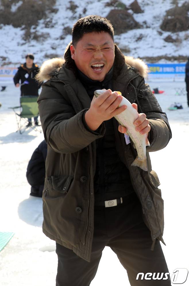 5일 강원 홍천군 홍천강변에서 열린 제6회 홍천강 인삼송어 축제에서 한 관광객이 송어를 잡고 기뻐하고 있다. 이번 축제는 오는 21일까지 계속되며 주요 프로그램은 얼음낚시, 가족텐트낚시, 인삼송어 맨손잡기 등이다. 2018.1.5/뉴스1 © News1 하중천 기자