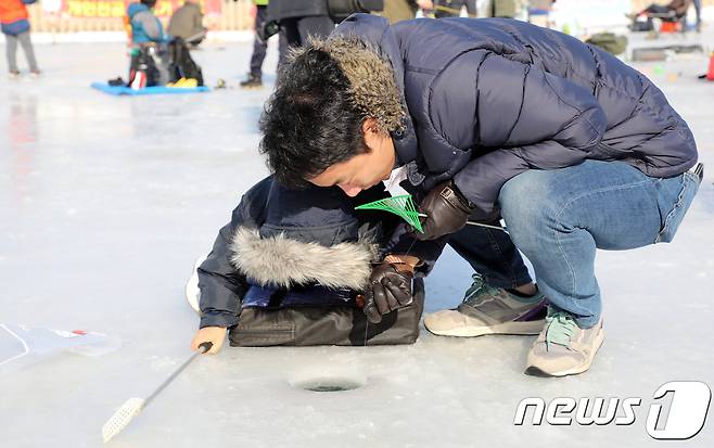 5일 강원 홍천군 홍천강변에서 열린 제6회 홍천강 인삼송어 축제에서 객들이 얼음낚시를 하고 있다. 이번 축제는 오는 21일까지 계속되며 주요 프로그램은 얼음낚시, 가족텐트낚시, 인삼송어 맨손잡기 등이다. 2018.1.5/뉴스1 © News1 하중천 기자