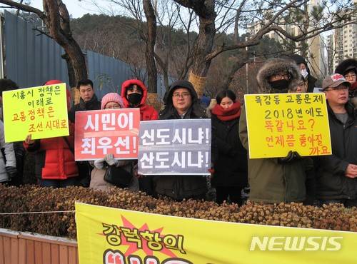 【시흥=뉴시스】이종일 기자 = 경기 시흥시 배곧신도시총연합회, 목감지구입주자대표회의 총연합회, 은계지구예비입주자대표회의 총연합회 등 3개 단체 회원들이 9일 시흥시청 정문 앞에서 집회를 열고 "버스 노선 개편으로 지옥버스 해결하라"고 촉구하고 있다. 2018.01.09.  lji22356@newsis.com