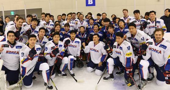 문재인 대통령이 남녀 아이스하키 선수단에게 받은 기념 유니폼을 입고 기념촬영을 하고 있다. 청와대사진기자단