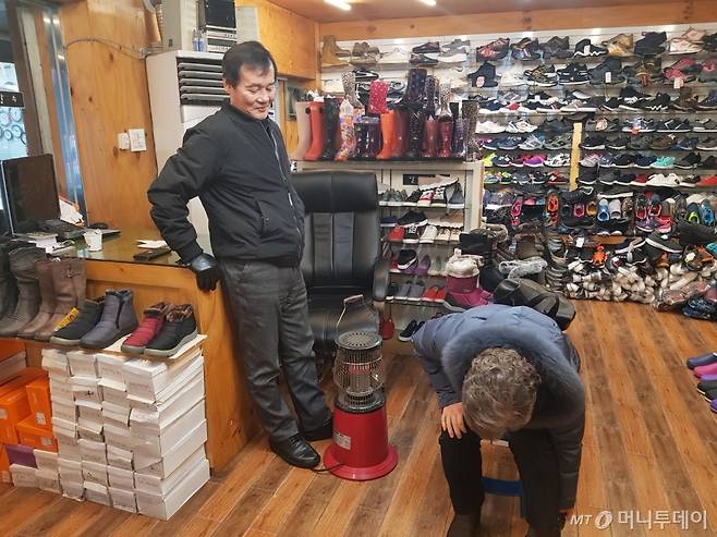 9일 서울 영도시장 입구 신발 가게 주인이 손님에게 신발을 설명하고 있다. /사진=이보라 기자