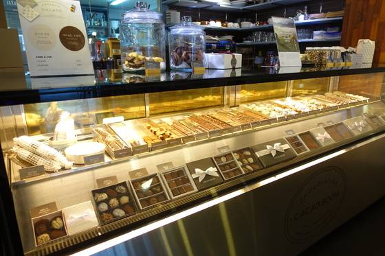 카카오봄 홍대점의 진열장 위 칸에는 낱개 판매 제품이, 아래 칸에는 선물용 상자포장 제품이 놓여있다. 위 칸 왼쪽에 망으로 싼 것은 살라미 모양 초콜릿이다. 살라미처럼 자르면 술 안주로도 좋다고 해서 먹어보니 의외로 잘 맞았다.