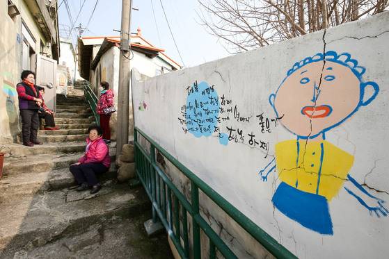 영화 ‘1987’ 속 ‘연희네슈퍼’가 자리한 전남 목포시 서산동 시화마을 주민들이 시와 그림으로 꾸민 골목에 모여 얘기를 나누고 있다. 프리랜서 장정필