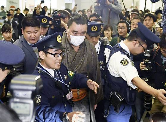 지난해 11월 16일 몽골 출신 하루마후지 선수가 폭행사건의 책임을 지고 은퇴 의사를 밝힌 뒤 마스크를 쓰고 하네다공항을 통해 출국하고 있다. 하루마후지는 같은 달 29일 정식 은퇴했다. [AP=연합뉴스] I