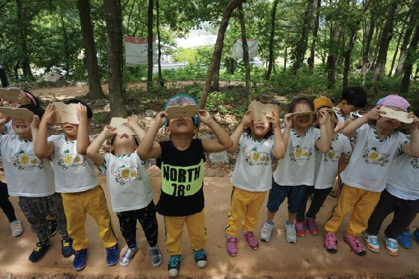 [월간산]칠곡숲체원 토리유아숲체험원에서 진행하는 프로그램에 참가한 어린이들이 기구를 이용해서 숲을 관찰하고 있다.