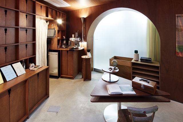 지하의 카페 겸 갤러리. 왼쪽에 보이는 나무 캐비닛이 작가들의 소품을 넣어두는 호텔 어라운드의 ‘객실’이다. 김용관 건축사진작가 제공