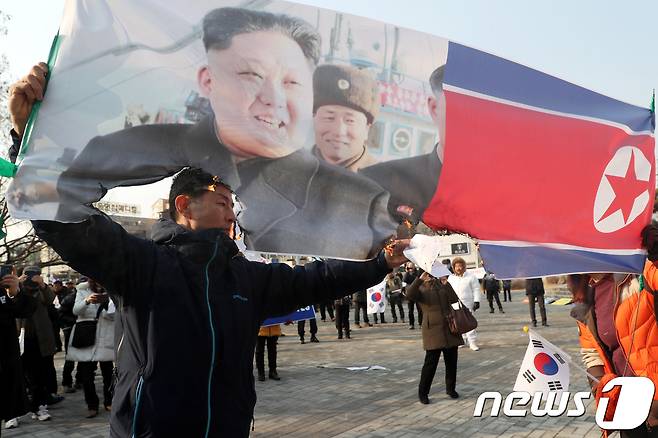 평창동계올림픽 개막식날인 9일 충북태극기애국시민연합이 충북 청주시 상당공원에서 평창동계올림픽 남북단일팀 출전 규탄집회를 열고 김정은 북한 노동당 위원장의 사진과 인공기를 불태우고 있다. 2018.2.9/뉴스1 © News1 김용빈 기자
