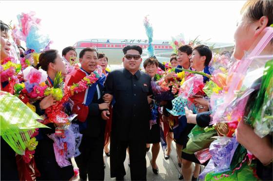 김정은 북한 국방위원회 제1위원장이 2015 동아시안컵에서 우승하고 귀국한 여자 축구선수들을 격려하기 위해 공항으로 마중을 나갔다고 조선중앙통신이 10일 보도했다. 이날 격려행사에 김 제1위원장의 부인인 이설주가 동행했다. 김광민 북한 여자 축구대표팀 감독이 평양 순안 국제공항에 도착한 김 제1위원장의 오른팔을 잡고 걸어가고 있다. [사진 제공=노동신문]
