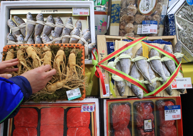 An employee at Hanaro Mart in Yangjae-dong, Seoul, adjusts a displayed gift set that comprises homegrown agricultural products to fit the revised limit of presents from 50,000 won to 100,000 won for the public sector. (Yonhap)