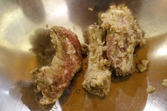 삭힌 등갈비는 밥알과 다진 마늘을 털어내고 튀긴다.