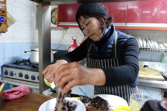 국이 끓는 동안 떡을 자르는 김정매씨. 넙도에서 태어나고 자랐다.