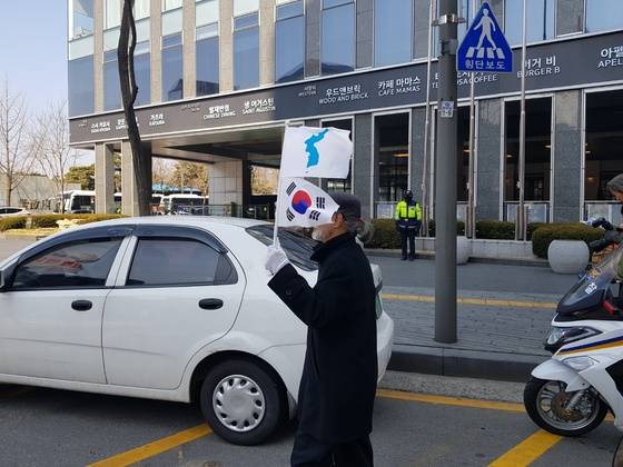 한반도기와 태극기를 같이 든 시민이 행진하고 있다. 정용환 기자