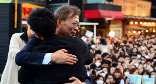 문재인 대통령이 더불어민주당 대선 후보 시절 지난해 5월6일 서울 마포구 홍대입구역 인근에서&nbsp;열린 '투표 참여 릴레이 버스킹 vote0509'에서 사전 투표율 25% 달성을 축하하는 프리허그 이벤트를 하고 있는 모습. 연합뉴스