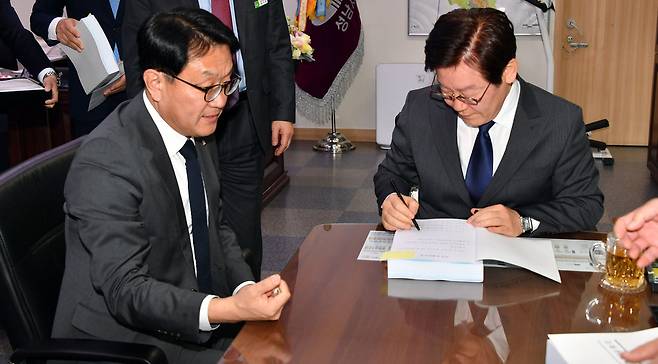 이재명 경기도 성남시장(오른쪽)이 14일 오전 시장 집무실에서 사무인계인수서를 작성해 이재철 부시장에게 시장 권한을 넘기고 있다. 성남시 제공