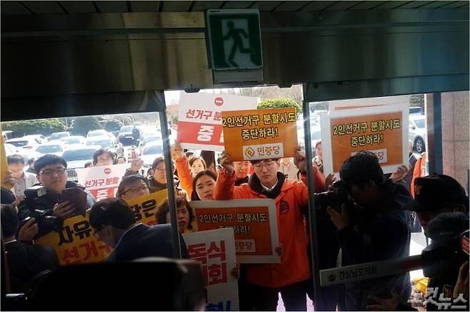 소수 정당 관게자와 시민사회단체들이 도의회 현관 앞을 가로막고 항의하고 있다.(사진=최호영 기자)