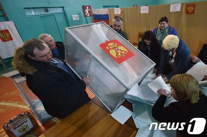 18일(현지시간) 러시아의 한 투표소에서 투표함이 비워지고 있다. © AFP=뉴스1