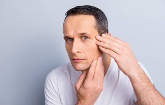 얼굴을 살피는 남성