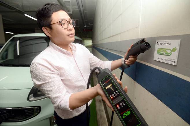 전기차 이용자가 파워큐브의 이동형 충전기로 충전 중인 모습.