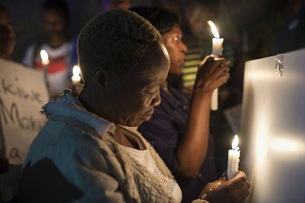 에시디메니 정신병원에 입원해있던 환자 1711명을 가족들의 동의 없이 미등록 시설로 옮기고 144명을 숨지게 한 가우텡 주정부에 항의하고 희생자를 추모하는 의미로 한 시민이 촛불을 들고 있다.  게티이미지코리아.