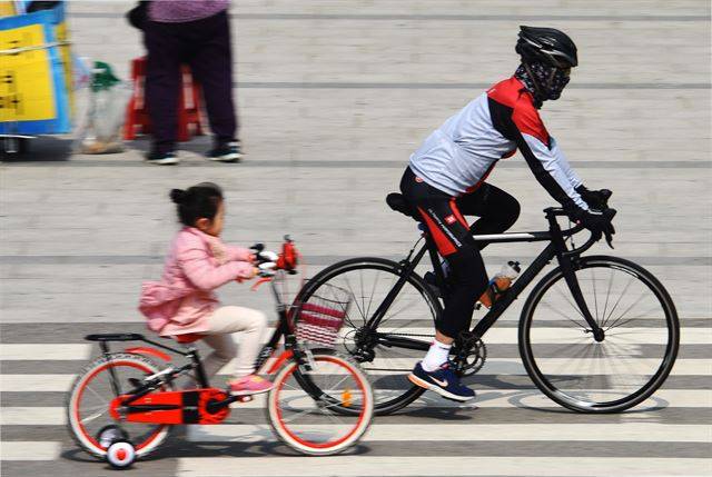 동일한 공간을 달리는 자전거라도 속도가 다른 탓에 추월과 역주행이 빈번하게 이루어진다. 한 로드 바이크 이용자가 어린이를 추월하고 있다.