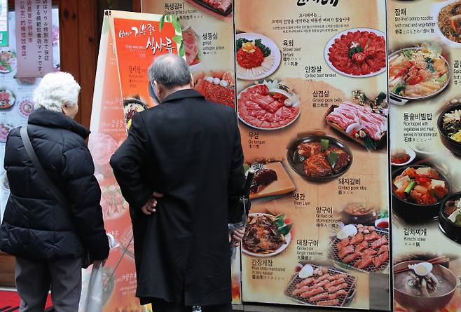 서울 중구 명동의 식당 앞에서 시민들이 음식 메뉴와 가격표를 바라보고 있다. 한국의 외식 인구는 날로 증가하고 있지만 음식문화의 만족도는 그에 미치지 못한다. 연합뉴스