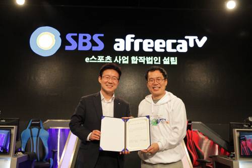 조재룡(왼쪽0 SBS 미디어비즈니스센터장과 서수길(오른쪽) 아프리카TV 대표가 e스포츠 공동사업 법인 설립에 대한 업무협약을 맺고 협약서를 교환하고 있다.