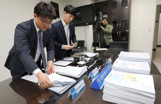 10일 오전 서울 강동경찰서에서 지능범죄팀 수사관들이 전국 규모의 대부업 범죄단체조직 총책 검거와 관련한 압수물을 살펴보고 있다. 이들은 고리대금업을 목적으로 전국 규모의 범죄단체를 조직한 뒤 2016년 6월부터 지난해 11월말까지 신용불량 등으로 금융권에서 소액조차 빌리기 어려운 서민들을 타킷으로 삼았다. [뉴스1]