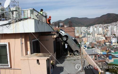 후진하다 추락한 택시 (부산=연합뉴스) 2017년 11월 12일 낮 12시 부산 서구 산복도로 인근의 한 주택 옥상 주차장에서 후진하던 A(71) 씨의 로체 개인택시가 난간을 들이받고 아래층 마당으로 추락했다. 사진은 사고 현장. 2017.11.12 [부산경찰청 제공=연합뉴스]