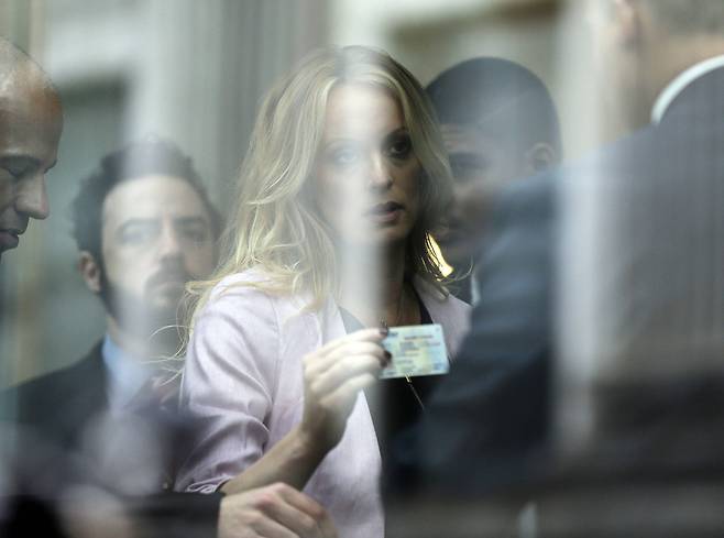 스토미 대니얼스가 연방법원에 출석해 법원 관계자에게 신분증을 보이고 있다. [AP=연합뉴스]