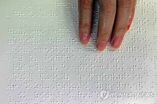 점자책 읽는 손 [연합뉴스 자료사진]