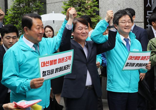안철수(가운데) 바른미래당 서울시장 후보가 22일 서울 광화문 광장 인근에서 열린 불법댓글공작 규탄대회에서 박주선(왼쪽) 유승민 공동대표와 손을 들어 올리고 있다. 연합뉴스