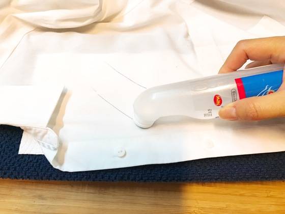 수건, 종이타월 위에 셔츠를 잘 펴서 올리고 물파스를 바른다. 단추 가까이에 있는 자국은 검은색 볼펜 자국, 그 위쪽에 있는 자국은 파란색 사인펜 자국이다.