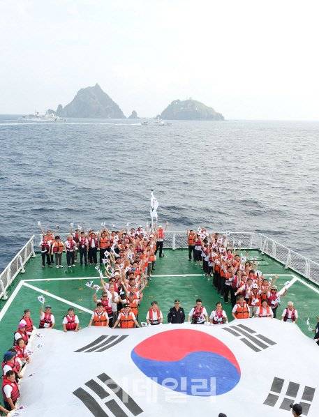‘제71주년 광복절 기념 독도 순례행사’ 참가자들이 15일 오전 5001함 헬기갑판에서 독도를 배경으로 숫자  ‘71’자로 대열을 맞춰 기념촬영을 하고 있다. (사진=전상희 기자)